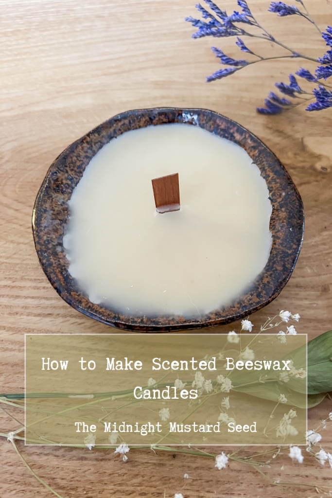 Coffee scented beeswax candle in ceramic candle jar with purple and white wildflowers around it.