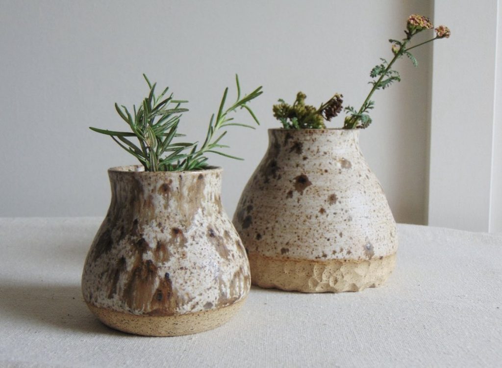 White and brown speckled glazed stoneware vases with wildflowers