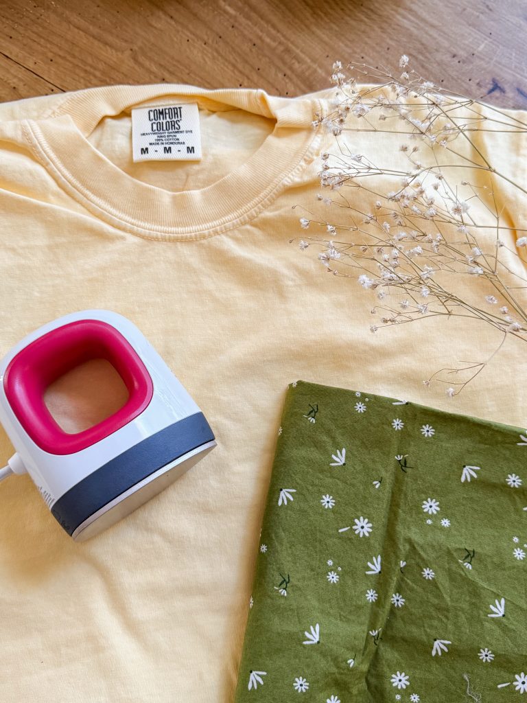 Cricut easy press mini, a butter yellow comfort colors shirt, and green floral fabric. How to make an iron on applique with Cricut cutting machine