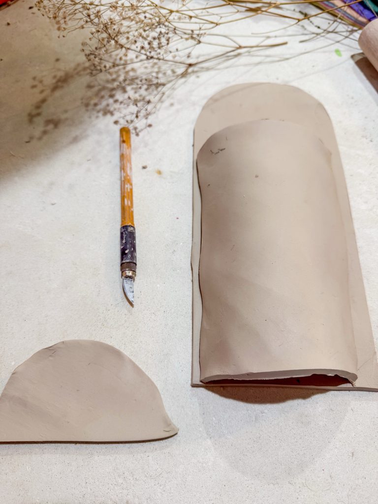 Pieces of potte dry slab being attached to make a ceramic wall planter. How to make a diy pottery wall planter by the midnight mustard seed