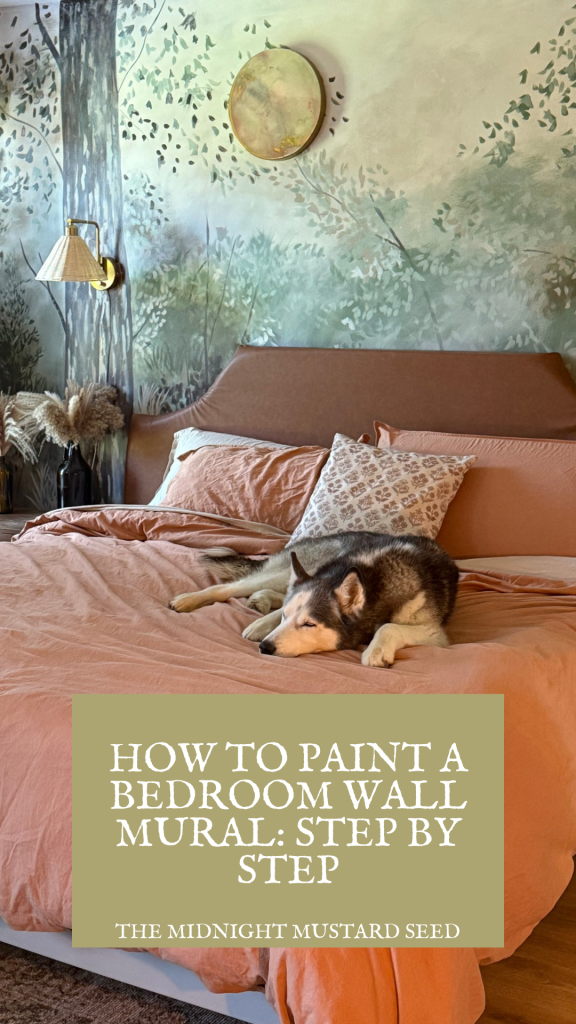A cozy bedroom features a bed with a peach-colored comforter and decorative pillows, where a dog is comfortably resting. The wall behind the bed showcases a beautifully painted mural with a forest theme, including trees and scattered leaves in muted green tones, complemented by a circular metallic wall decoration. A wall-mounted lamp with a beige shade and a vase with dried pampas grass add to the room’s warm ambiance. The image, featured in a blog on how to paint murals, includes a text overlay that reads, “HOW TO PAINT A BEDROOM WALL MURAL: STEP BY STEP” in bold white letters on a green background, with “THE MIDNIGHT MUSTARD SEED” written below in smaller text.