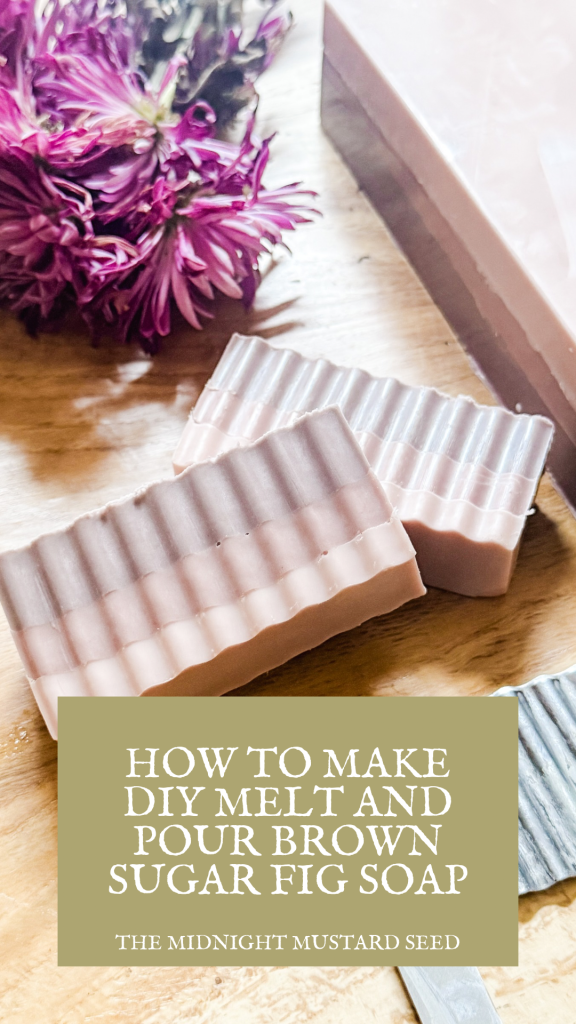 How to Make DIY Melt and Pour Brown Sugar Fig Soap by the midnight mustard seed blog. light purple soap loaf and handmade soap bars on a wooden table with purple flowers in the background
