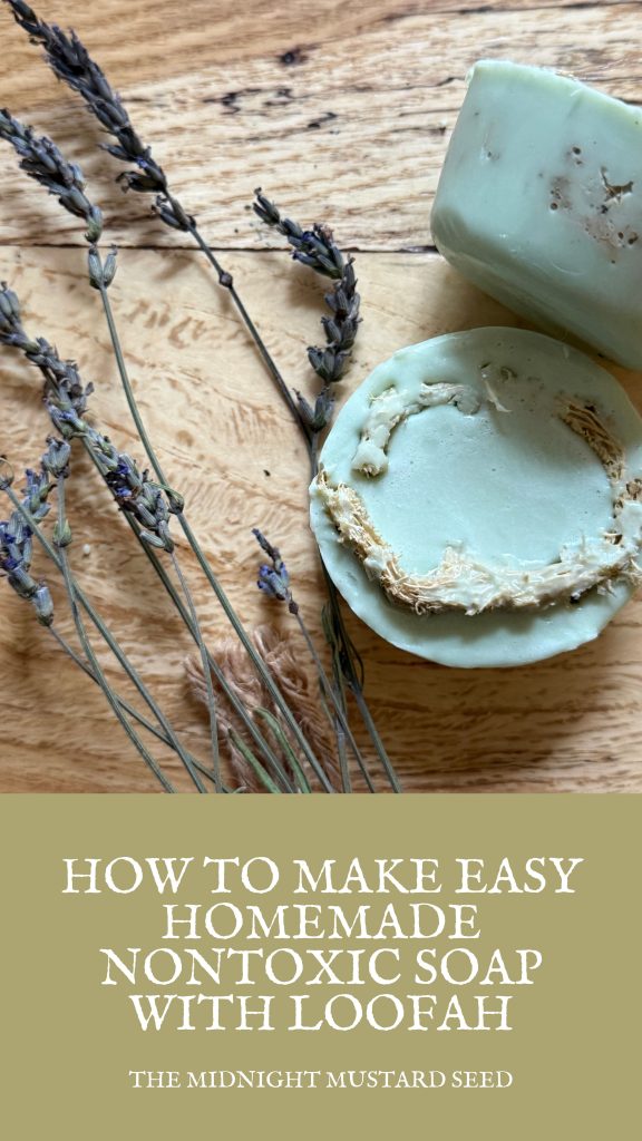 Close-up of a round homemade non-toxic lavender soap bar in pale mint green color, showing a textured natural loofah sponge embedded in the top layer, surrounded by fresh and dried lavender sprigs on a rustic wooden background”